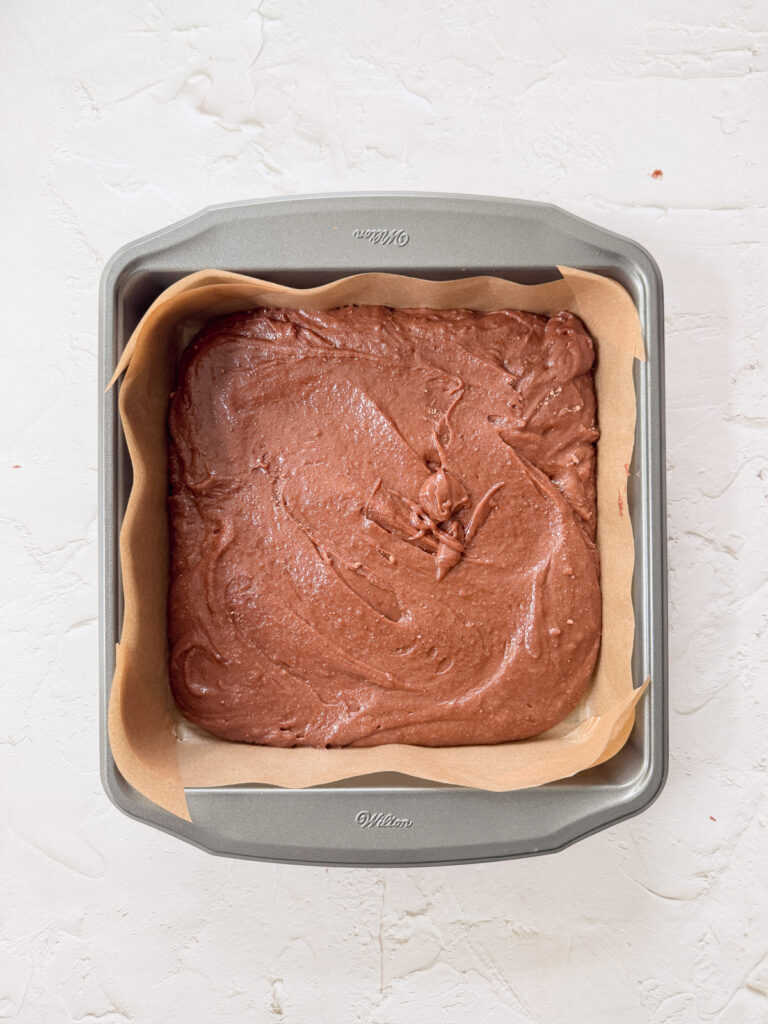 First layer of brownie added to pan